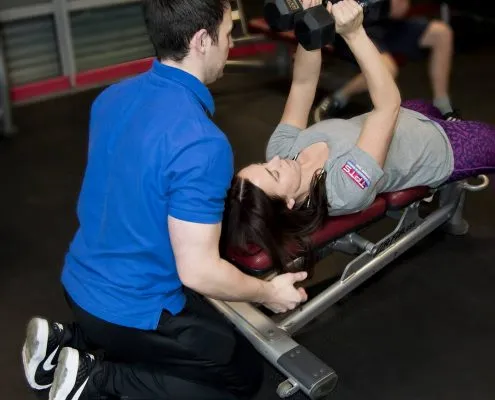 darren assisting his personal training client with dumbbell flys