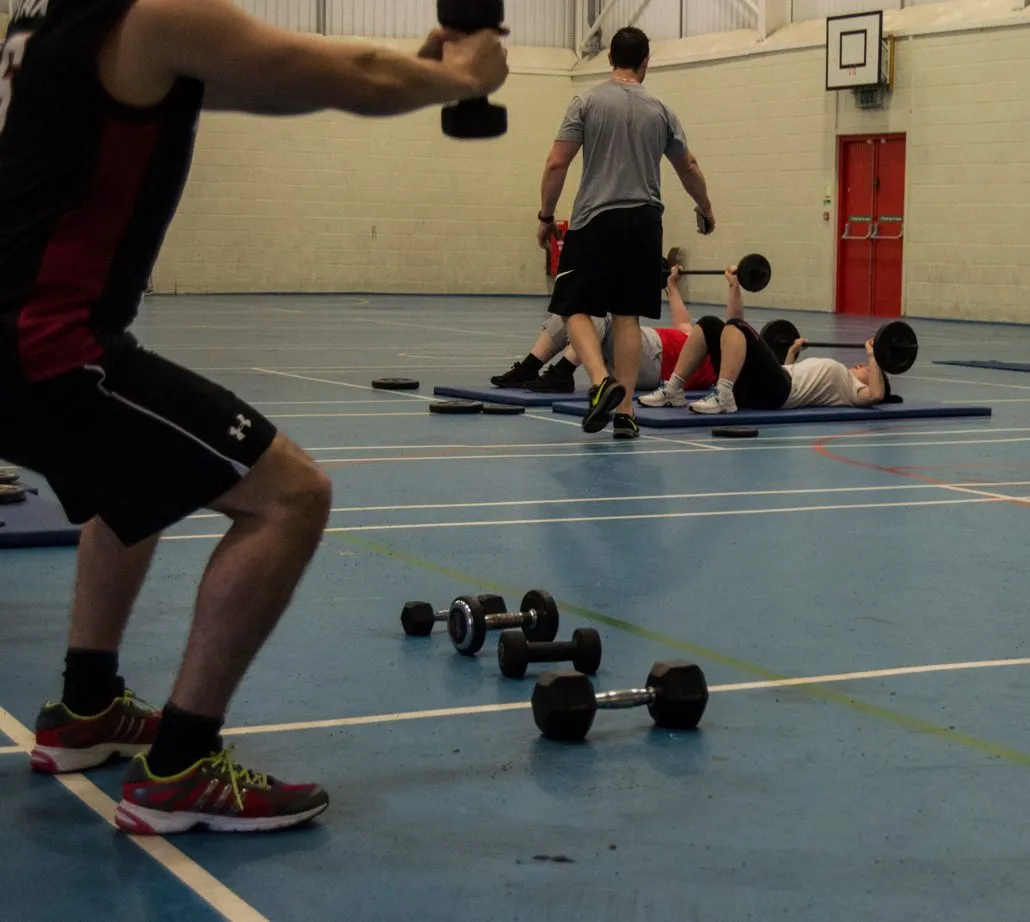 Image of multiple clients performing exercises in the sports hall of TPTS fitness club