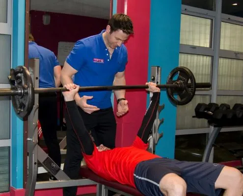 TPTS client being spotted on bench press by personal trainer darren
